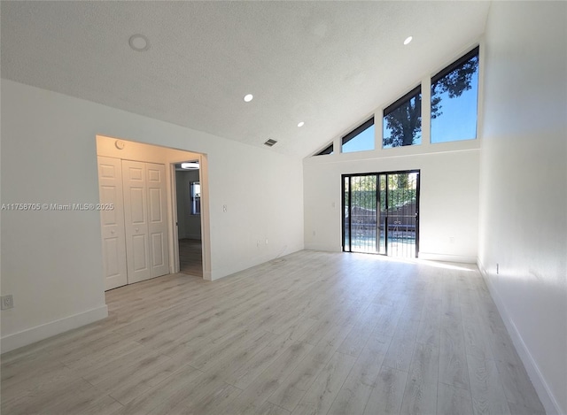 unfurnished room with a textured ceiling, high vaulted ceiling, light wood-style flooring, recessed lighting, and baseboards