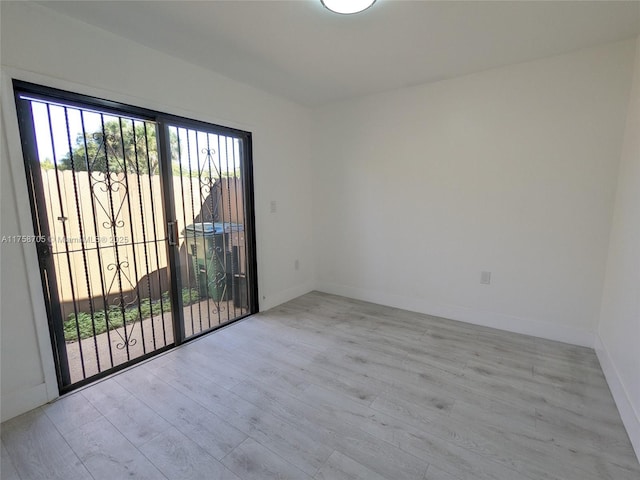 spare room featuring baseboards and wood finished floors