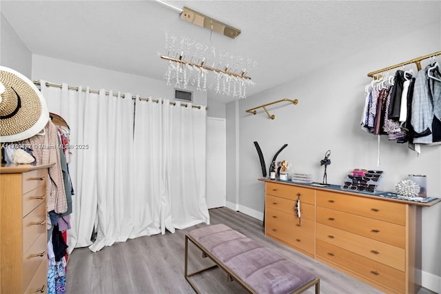 walk in closet featuring wood finished floors and visible vents