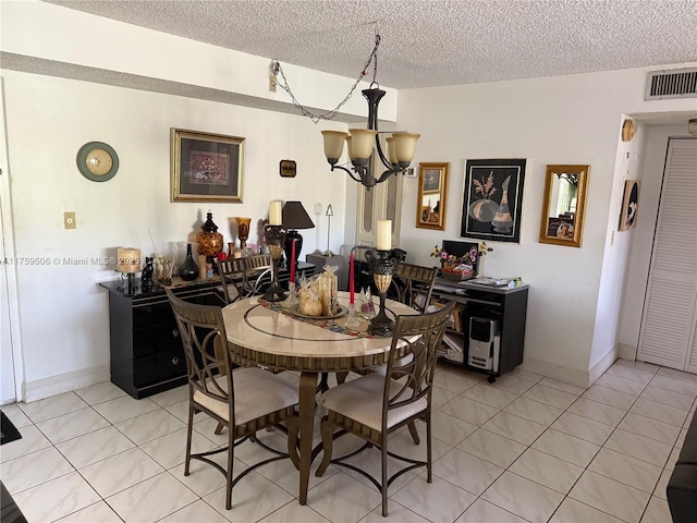 dining space featuring light tile patterned floors, visible vents, a chandelier, and a textured ceiling