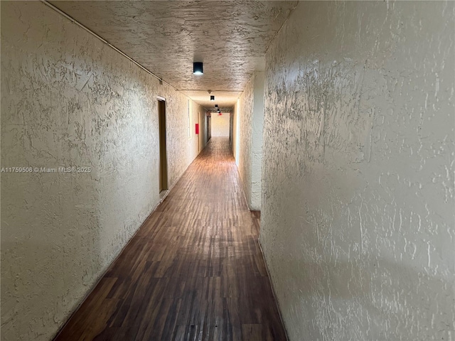 corridor featuring a textured wall and wood finished floors