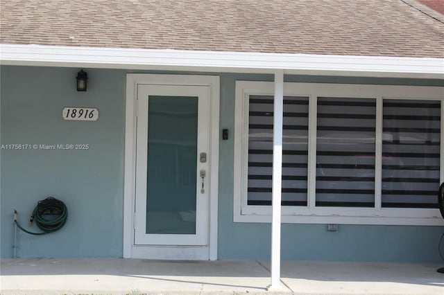 property entrance with roof with shingles