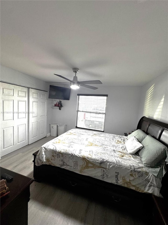 bedroom with ceiling fan, a closet, and light wood-style flooring