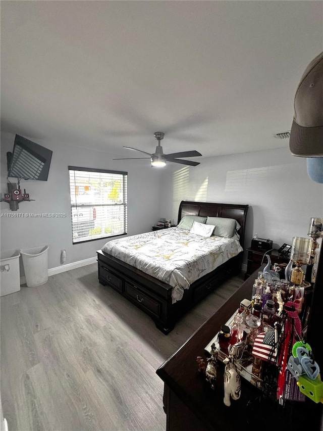 bedroom with baseboards, a ceiling fan, and wood finished floors