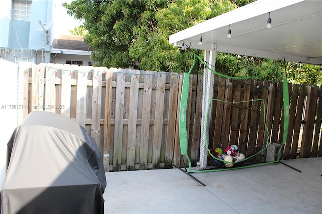 view of patio with area for grilling and fence