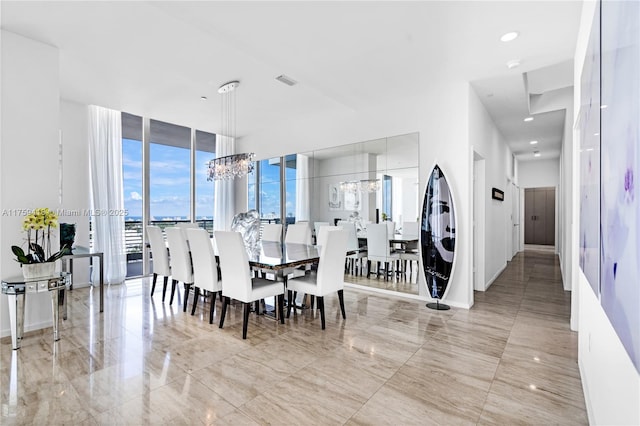 dining area featuring a chandelier, marble finish floor, baseboards, and floor to ceiling windows