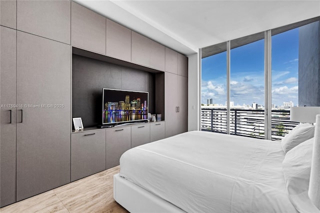 bedroom with floor to ceiling windows and access to exterior