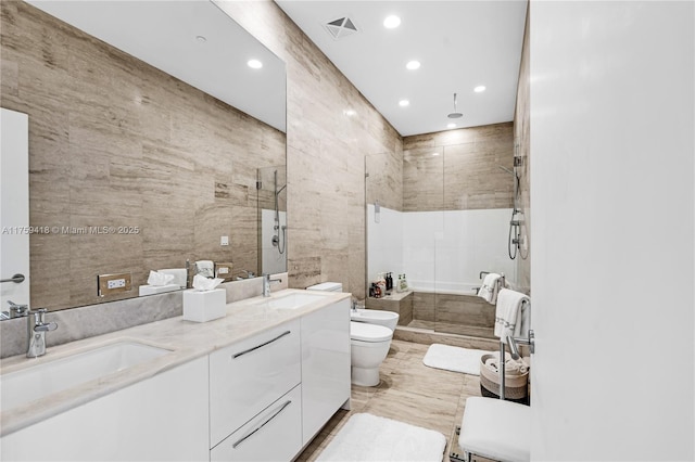 full bath with a sink, visible vents, tile walls, a shower stall, and a bidet