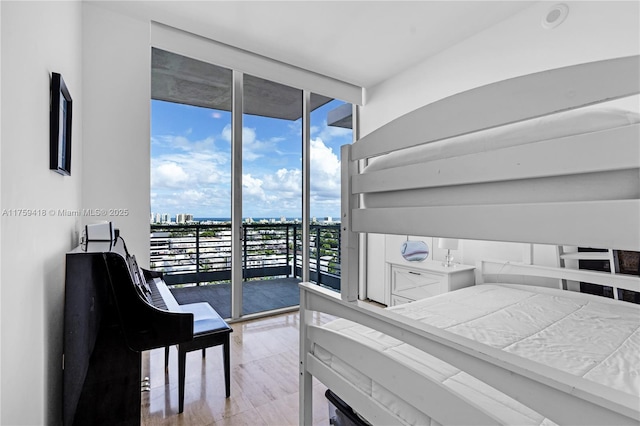 bedroom with expansive windows, access to outside, and a city view