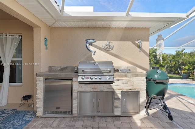 view of patio / terrace featuring glass enclosure, exterior kitchen, grilling area, and an outdoor pool