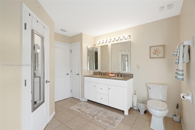 full bath featuring double vanity, visible vents, toilet, tile patterned floors, and a sink