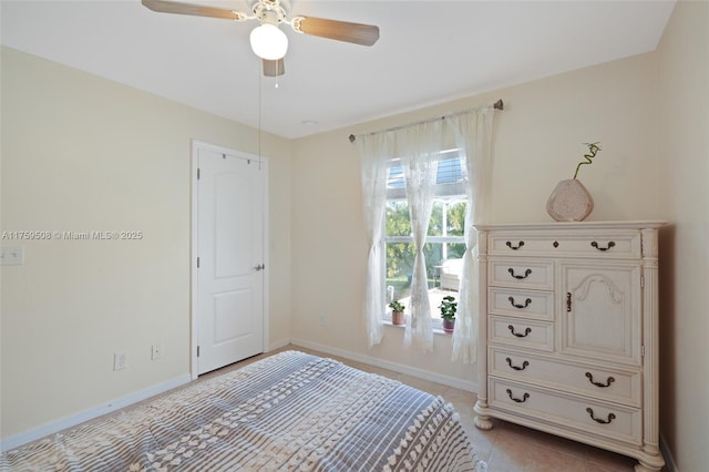 unfurnished bedroom with ceiling fan, baseboards, and light tile patterned floors