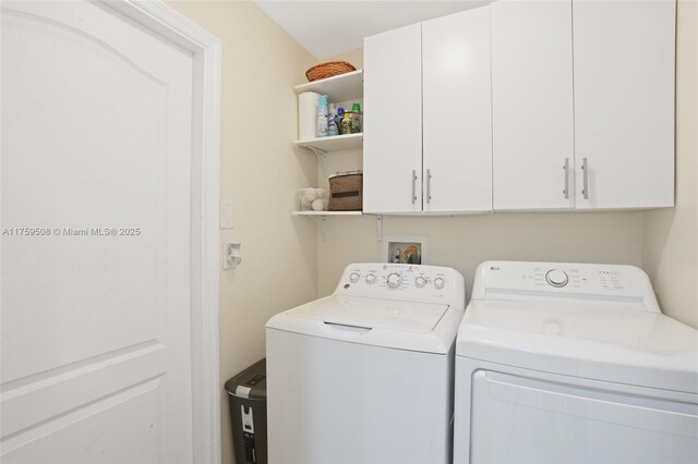 washroom featuring washing machine and dryer and cabinet space