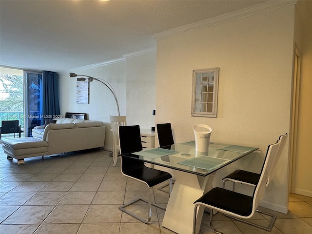 dining room featuring light tile patterned floors, baseboards, a wall of windows, and crown molding