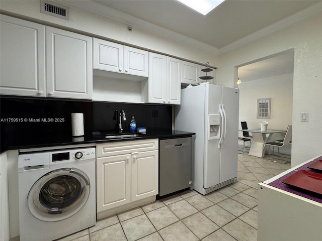 kitchen with white refrigerator with ice dispenser, washer / clothes dryer, visible vents, a sink, and dishwasher