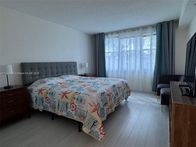 bedroom featuring light wood-style floors and a textured ceiling