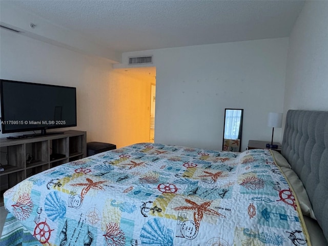 bedroom featuring a textured ceiling and visible vents