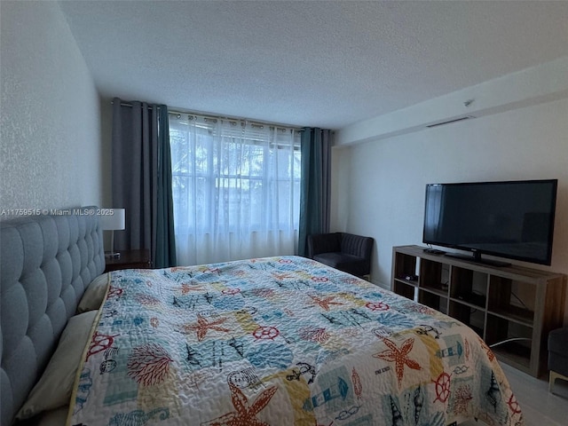 bedroom featuring a textured wall and a textured ceiling