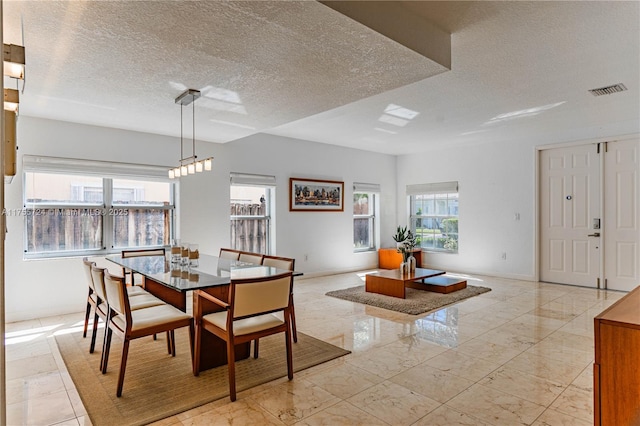 dining area with marble finish floor, visible vents, a textured ceiling, and baseboards