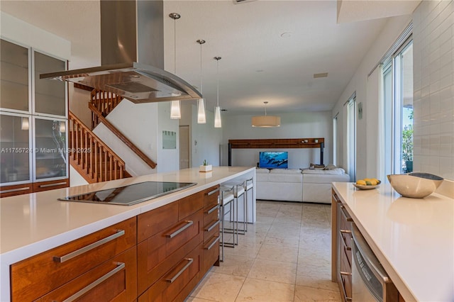 kitchen with black electric stovetop, island range hood, open floor plan, light countertops, and brown cabinets