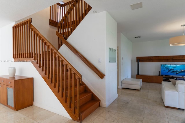 staircase featuring baseboards and visible vents