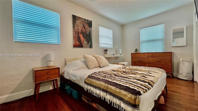 bedroom with wood finished floors and baseboards