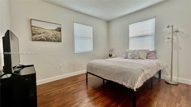 bedroom with baseboards and wood finished floors