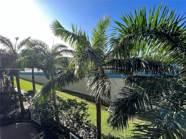 view of property's community featuring a yard and fence