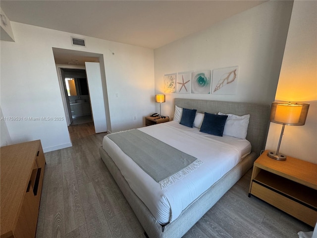 bedroom featuring visible vents and wood finished floors