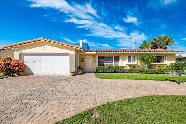 ranch-style home featuring an attached garage, a tile roof, decorative driveway, and stucco siding