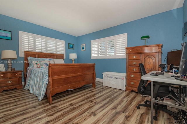 bedroom with baseboards and wood finished floors