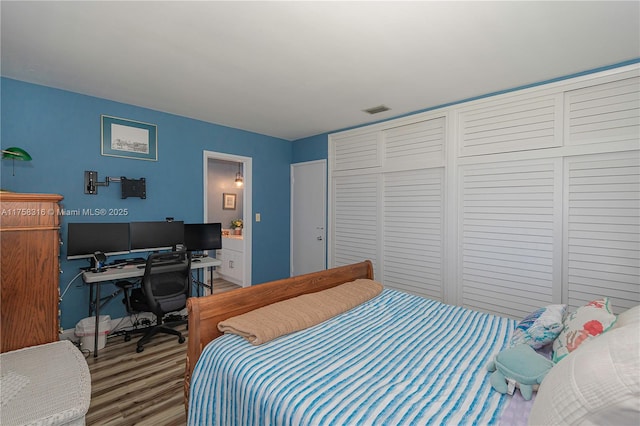 bedroom featuring wood finished floors and visible vents