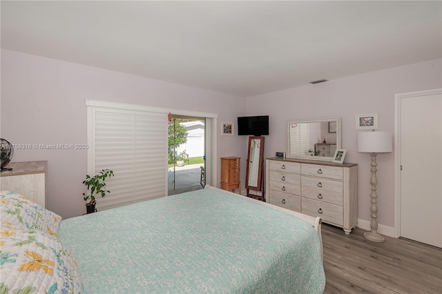 bedroom with visible vents, baseboards, and wood finished floors