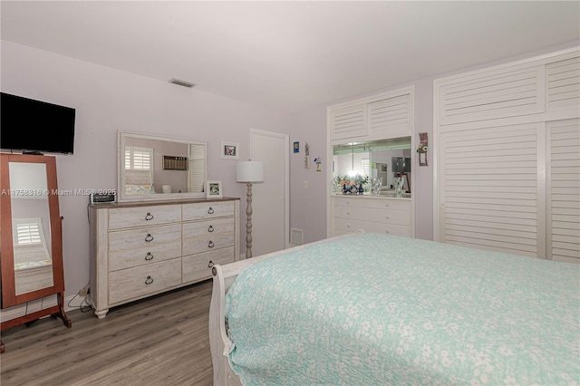 bedroom with visible vents and wood finished floors