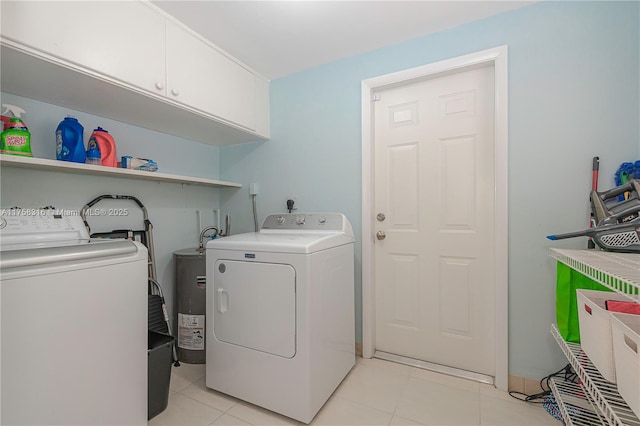 laundry area featuring cabinet space, light tile patterned floors, and washing machine and clothes dryer