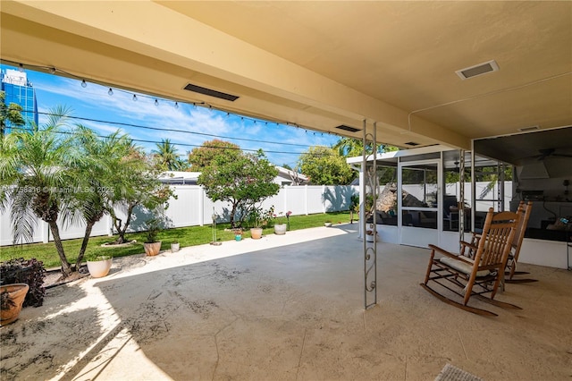 view of patio featuring glass enclosure and a fenced backyard