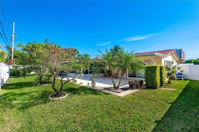 rear view of house with a patio, a fenced backyard, a tiled roof, and stucco siding