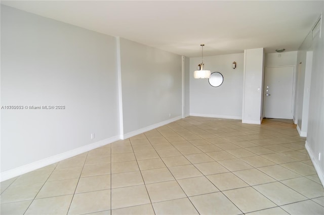 spare room with light tile patterned floors and baseboards