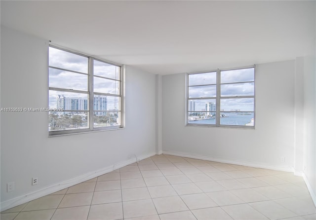 empty room featuring light tile patterned floors and baseboards