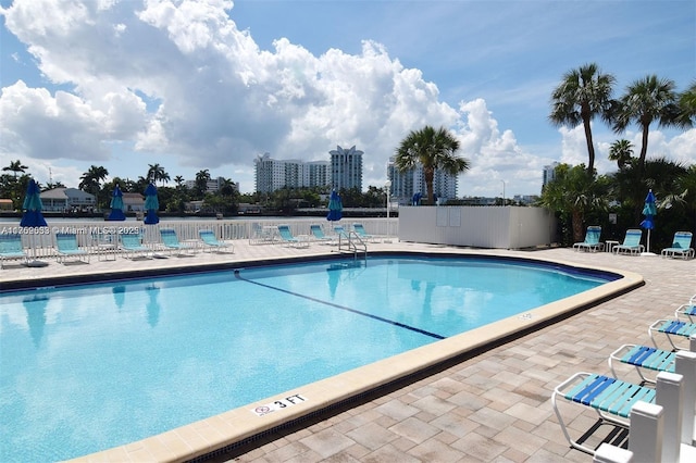 pool with a view of city, fence, and a patio