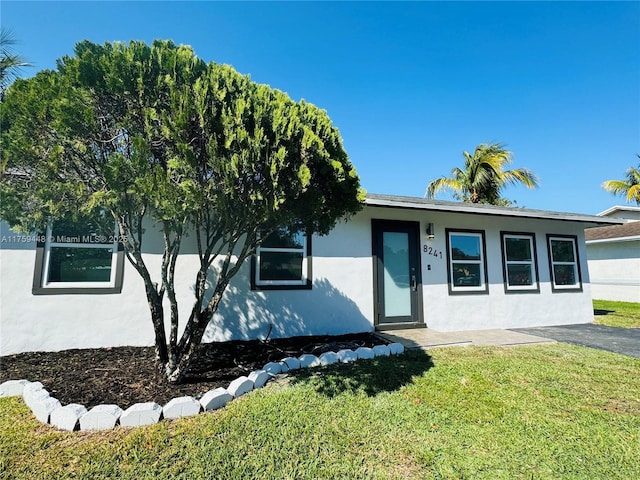 view of front facade with a front lawn and stucco siding