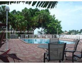 community pool featuring a patio, outdoor dining area, and fence