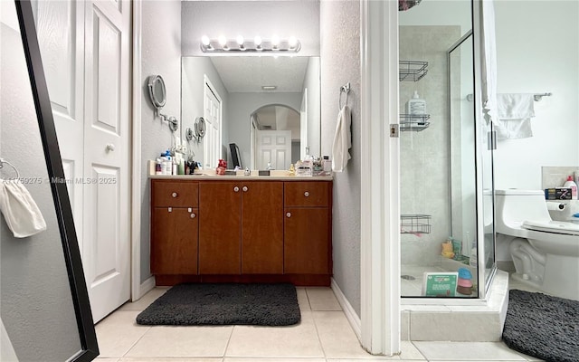 bathroom with a stall shower, baseboards, toilet, tile patterned floors, and vanity