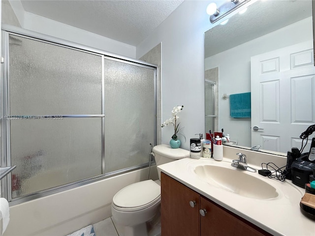 full bathroom featuring toilet, shower / bath combination with glass door, tile patterned floors, a textured ceiling, and vanity