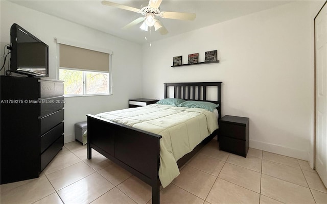 bedroom with ceiling fan, baseboards, and light tile patterned flooring