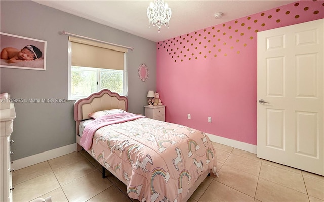 bedroom with a chandelier, baseboards, and light tile patterned floors