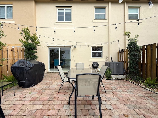 view of patio with outdoor dining area, fence, grilling area, and central air condition unit