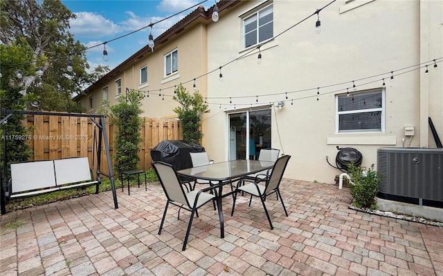 view of patio featuring outdoor dining area, central AC, and fence