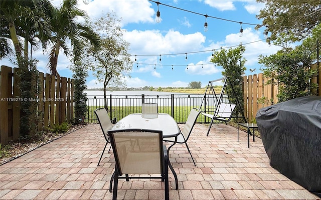 view of patio featuring outdoor dining area, a fenced backyard, and a grill