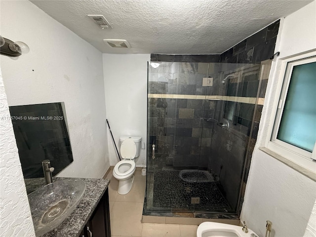 bathroom with visible vents, toilet, a stall shower, a textured ceiling, and tile patterned floors